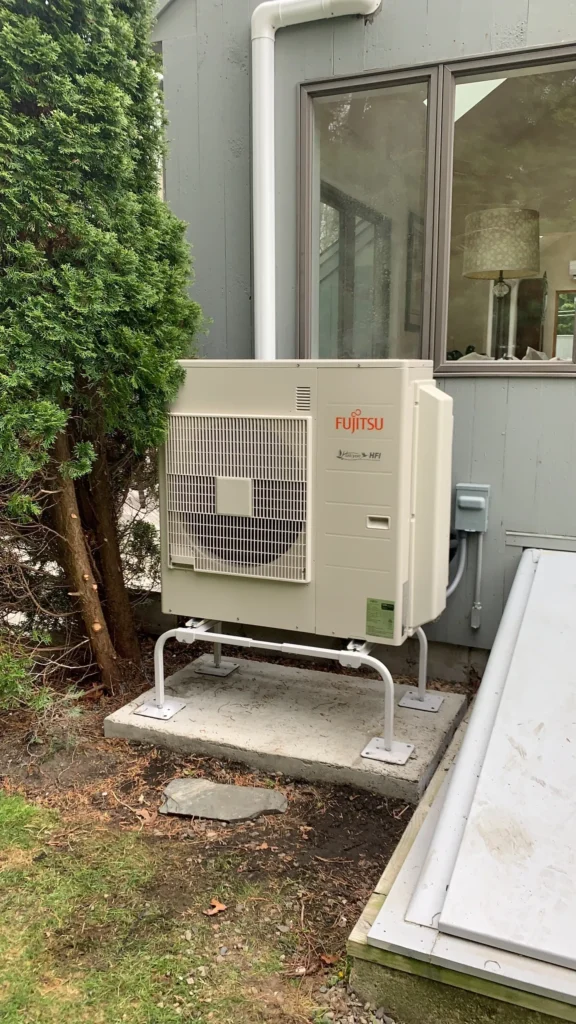 A small air conditioner sitting outside of a house.