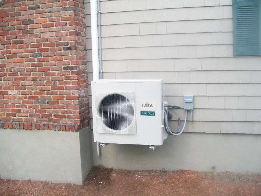 A small air conditioner mounted to the side of a building.