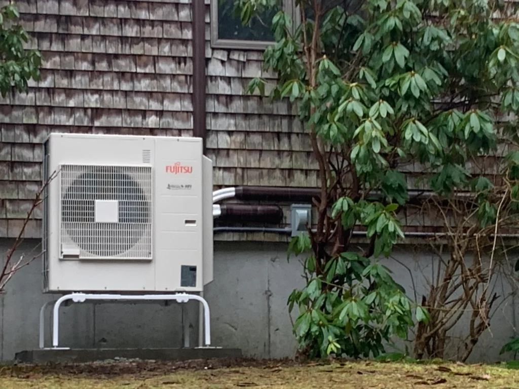 A small air conditioner sitting outside of a house.