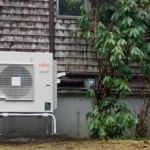 A small air conditioner sitting outside of a house.