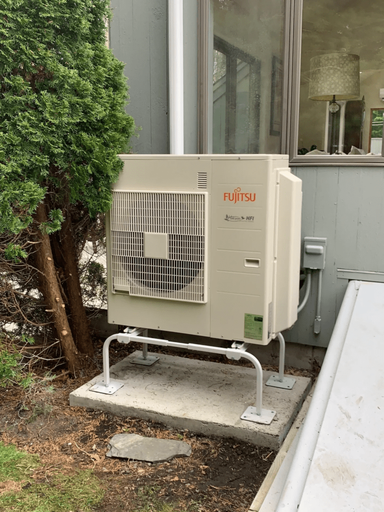 A small heat pump sitting outside of a house.