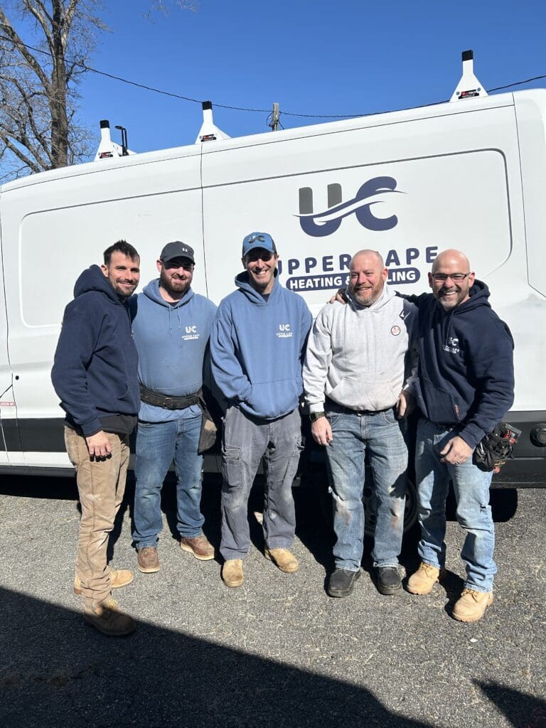 A group of men standing in front of a truck.